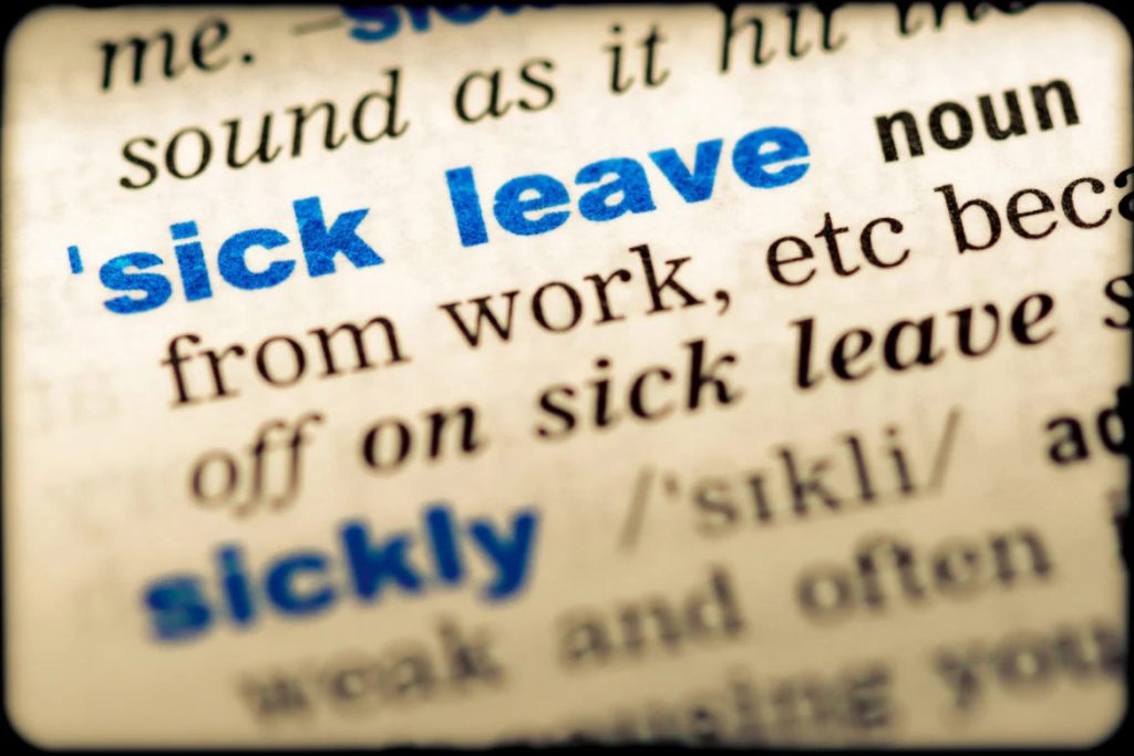 A close up of the word sick leave in a dictionary